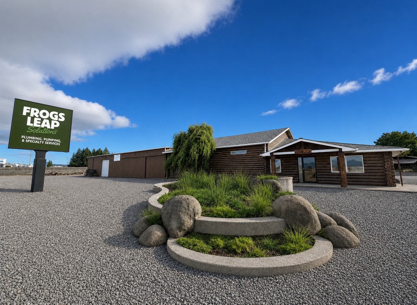 The Frogs Leap Solutions building in Eugene, Oregon: a single-story log-sided office with a covered entry, its branded monument sign and landscaped rock garden out front
